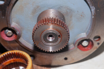 A removed electric motor with a gear on its shaft.