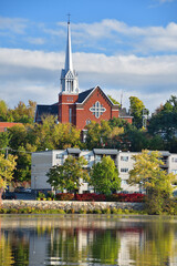 Sherbrooke Ste-Therese church cityscape with Nation lake in the foreground during early fall