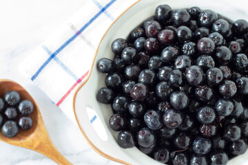 Ripe chokeberries (aronia fruit) in a bowl. Top view. Close-up.