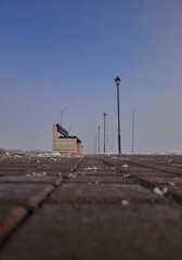 Bench and street lamp on the promenade in the morning