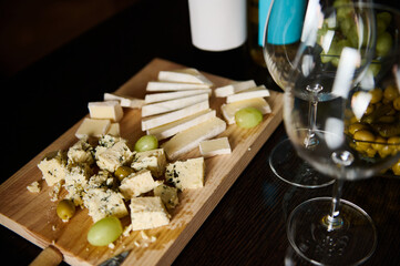 Cheese platter with grapes and wine glasses for a sophisticated gathering