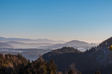 Panoramic view of Pyramidenkogel in Rosental Valley in winter seen from mount Petelin in Faak, Carinthia, Austria. Alpine landscape in soft light. Austrian Alps shrouded in mist. Serenity and calmness