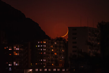 夕闇のマンションの背後に沈んでゆく月齢1の細い月20250101-2