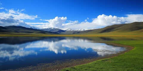 Obraz premium A large body of water with a blue sky in the background. The water is calm and still, reflecting the sky above. The scene is peaceful and serene