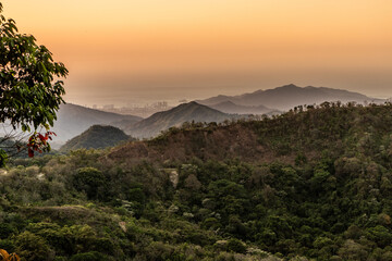 Evening view of lush mountains near Minca, Colombia. Santa Marta city in the background.