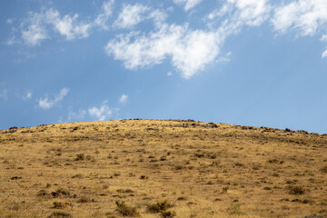 middle eastern landscape hills mountains and trees with blue skies 