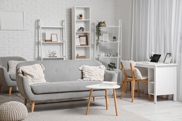 Interior of modern living room with grey sofa and books on coffee table