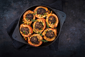 Traditional half quince stuffed with minced lamb meat, herbs and pine nuts as top view in cast iron skillet