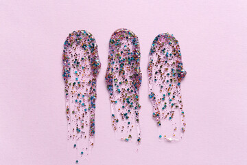 Three glitter swatches on pink background, cosmetic product texture, beauty and makeup concept,...