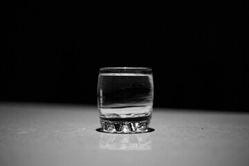 glass of water on a table with black background