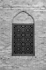 islamic geometric design window on a brick wall in black and white persian architecture window 