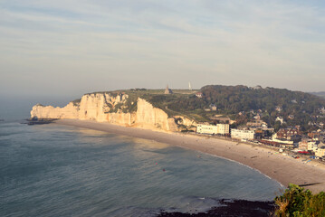 View of the coastal village of Etretat with white cliffs at golden hour