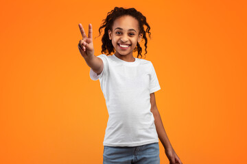 Celebrating Success. Portrait of young African American girl with curly hair wearing casual t-shirt...