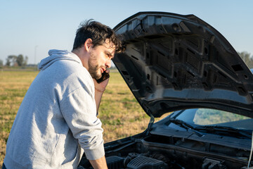 Hombre en apuros pidiendo ayuda por teléfono porque su auto se averió