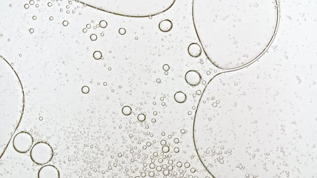 Transparent cosmetic gel fluid with molecule bubbles oil distribution. Bubble cluster, cells under a microscope. Macro Shot of Natural Organic Cosmetics, Medicine. Production Close-up. Slow Motion. 4k