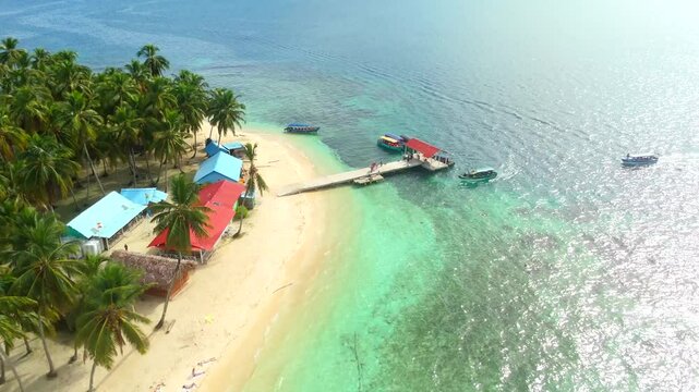 Aerial view of a beautiful tropical island with palm forest and dock in the Caribbean Sea. San Blas Islands In Panama. drone shot