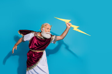 Photo of handsome senior male throw lightning storm punishment wear ancient greek god king dress...