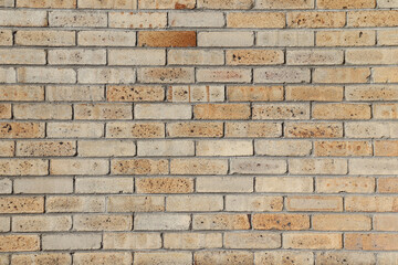 A close-up of an wall of a building with bricks. Construction material with yellow and brown...