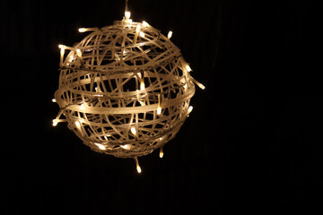 Obraz premium A big ball with lights and a black background. Festivities and outdoor lights. Holidays decorations and spere with little lights.