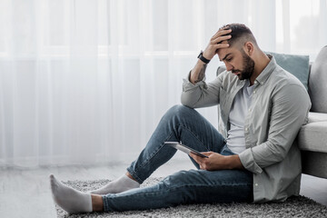 Man is chatting on phone at home feeling stress, bad news, boredom alone. Sad despair serious...