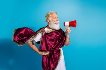 Photo of ancient dictator wearing traditional king mantle hold toa isolated on blue color background