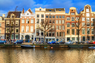 Cityscape on a sunny winter day - view of the houses and the city canal with boats in the historic...