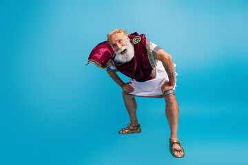 Photo of cheerful old man antique ancient athens traditional clothes garment isolated on blue color...