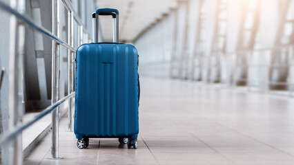 Closeup Shot Of Stylish Cabin Baggage Suitcase Standing In Empty Airport Hall, Blue Hand Luggage...