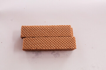 Small chocolate wafer bars, textured, neatly arranged in a row, irregular, snack, long, patterned arrangement, stacked, isolated on background