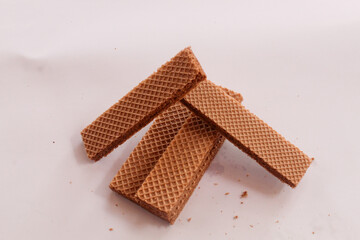 Small chocolate wafer bars, textured, neatly arranged in a row, irregular, snack, long, patterned arrangement, stacked, isolated on background