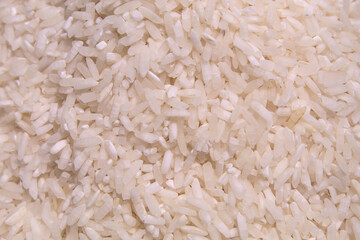The texture of a pile of white raw rice, close up