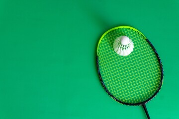 Badminton rackets and shuttlecocks on green background. copy space