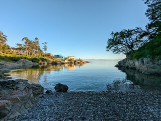 Obraz premium Golden sunset light illuminates the coast of Vancouver Island BC Canada with the Olympic mountains visible in the background 