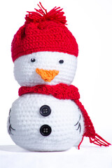 A white snowman with a red hat and scarf