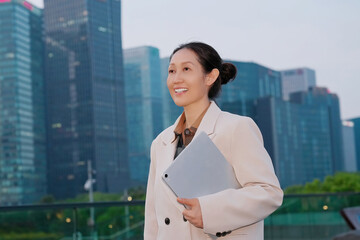 Confident Businesswoman Enjoys Evening Cityscape with Tablet in Hand