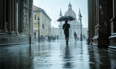 Obraz premium Rainy city street; person with umbrella, walking away.