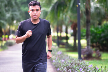 Asian male runner in the park on a sunny day in spring or summer