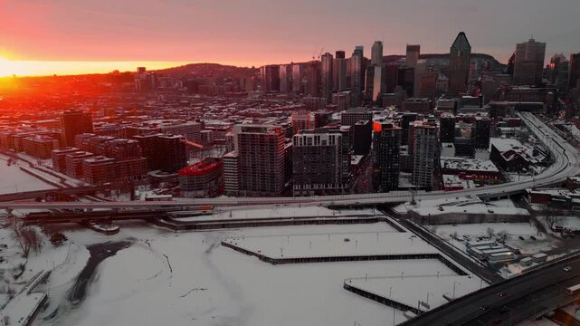 aerial shot over Montreal city at sunset during winter season revealing the skyline and Lachine canal, Quebec region, Canada