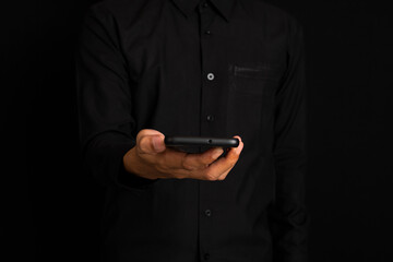 Middle part of businessman using smart phone while standing with black backgriund background.