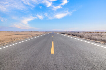 Asphalt highway road and desert with beautiful sky clouds natural landscape in Xinjiang, China. Outdoor road background.