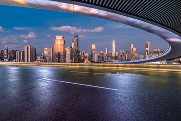 Asphalt highway road and bridge with modern city buildings at night in Shenzhen, China. Outdoor road background.
