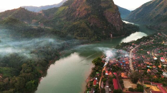 aerial sunset view of Nong Khiaw village in the Luang Prabang Province of northern Laos on the Nam Ou River drone footage travel destination south east Asia 