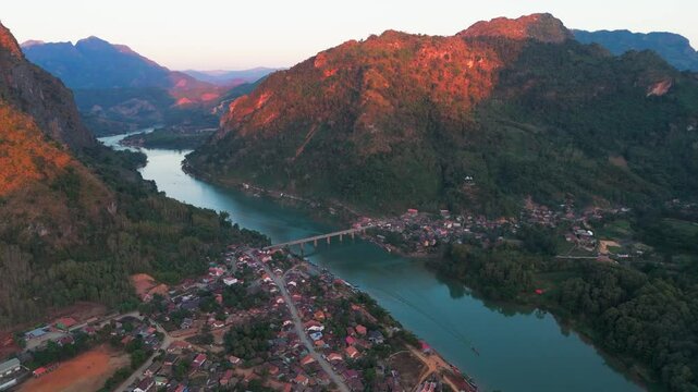 aerial sunset view of Nong Khiaw village in the Luang Prabang Province of northern Laos on the Nam Ou River drone footage travel destination south east Asia 