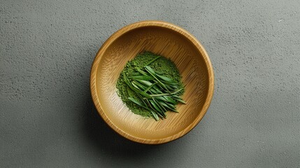 Green tea leaves and matcha powder in a wooden bowl. 