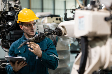 Robotic engineer automatic mechanic checking quality system of automation robot arms machine in factory. Service programming machinery welding robots in production at factory industry.