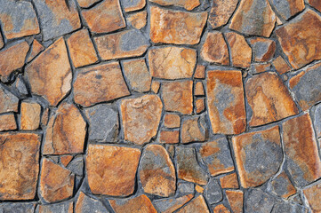 Fragment of a wall from a chipped stone. Wide panoramic stone pattern. The surface of natural masonry. The structure is in the grunge style.