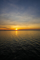 Naklejka premium Natural Sunset Sunrise Over Sea, Bright Dramatic Sky And Dark Ground. Countryside Landscape Under Scenic Colorful Sky At Sunset Dawn Sunrise. Sun Over Skyline, Horizon. Warm Color.