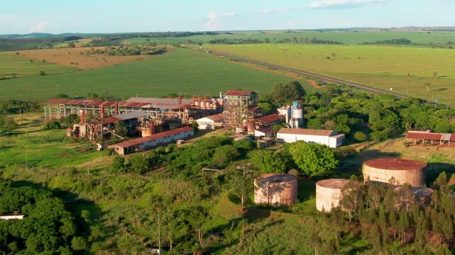 Drone pushes towards to historic Usina Agrest ethanol distillery in Esp&iacute;rito Santo do Turvo, S&atilde;o Paulo, Brazil, surrounded by lush greenery.
