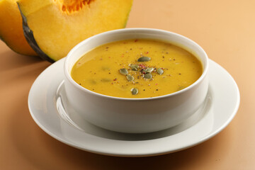 Pumpkin traditional soup with creamy silky texture garnished with pumpkin seeds 