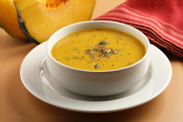 Pumpkin traditional soup with creamy silky texture garnished with pumpkin seeds 